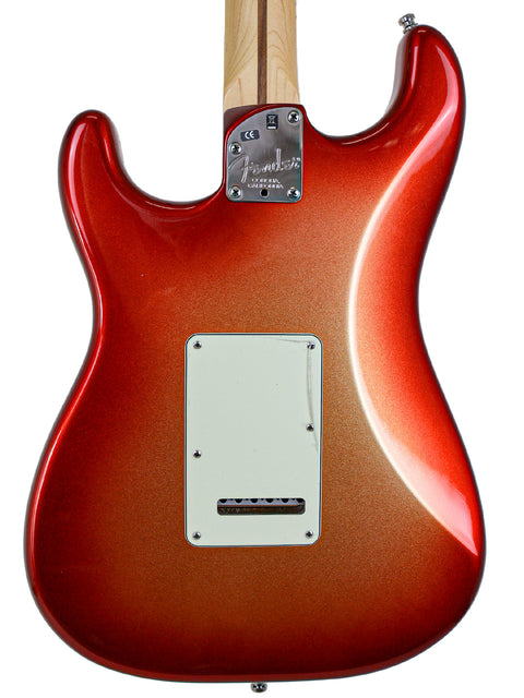 Red electric guitar body with a maple neck and no strings.