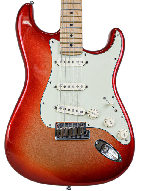 Red electric guitar with a maple neck and white pickguard on a white background.