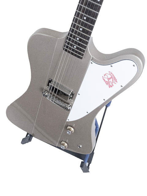 Silver electric guitar with a logo on the body standing upright on a white background.