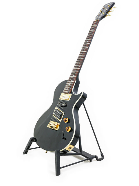 Stunning black electric guitar, Gibson Nighthawk USA 1999, displayed on a stand, ideal for serious guitar enthusiasts.