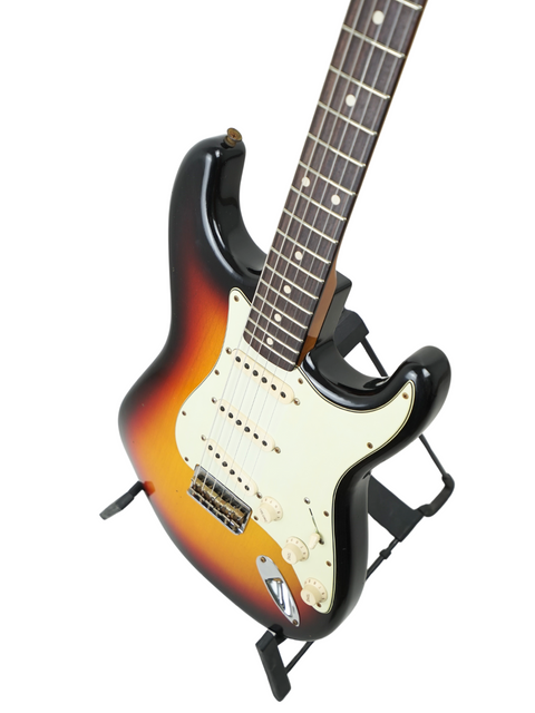 Sunburst-finished Fender Custom Shop '60 Stratocaster Hardtail on a stand, showcasing its elegant design.
