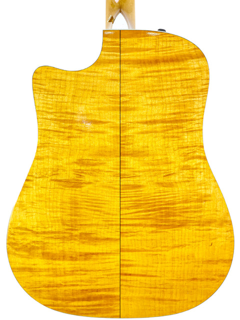 The back of a 2003 Taylor 610CE acoustic guitar, featuring a vibrant yellow finish that highlights its elegant curves.