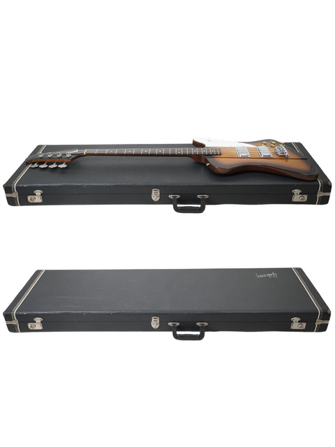 Two guitar cases hold a vintage 1976 Gibson Bicentennial Thunderbird IV Bass on top, celebrating its timeless appeal and artistry.