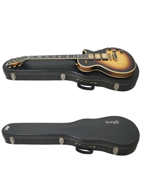 Two guitars, featuring a 1978 Gibson Les Paul Artisan, securely placed in a case for protection and display.