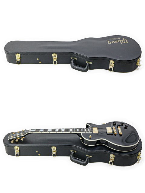 Two guitars in black cases set against a white background, showcasing a 2010 Gibson Custom Shop Les Paul Custom.
