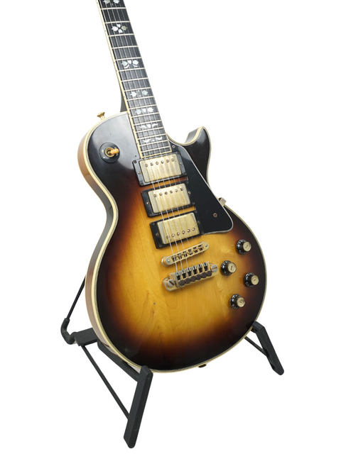 Vintage 1978 Gibson Les Paul Artisan guitar displayed on a stand, highlighting its exquisite sunburst finish and classic appeal.