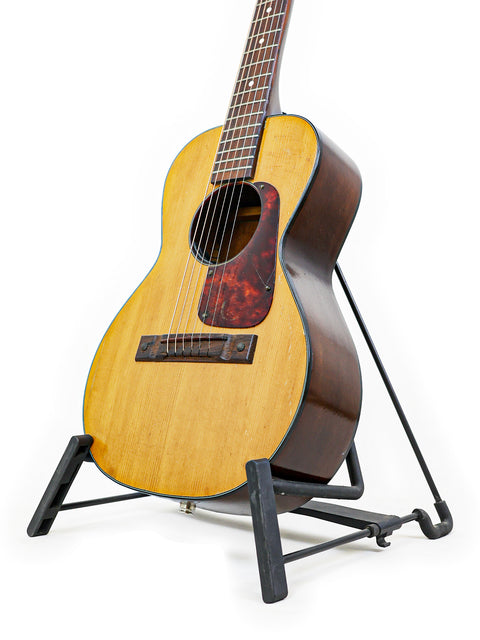 Vintage Kay K113 Parlour Guitar (1966-68) elegantly positioned on a stand with a bright white backdrop.
