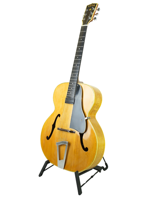 Vintage Vega C-66 guitar from 1940 on a stand, contrasting beautifully with a plain white background.