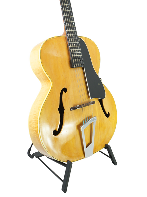 Vintage Vega C-66 guitar on a stand, showcasing its classic design against a clean white background.