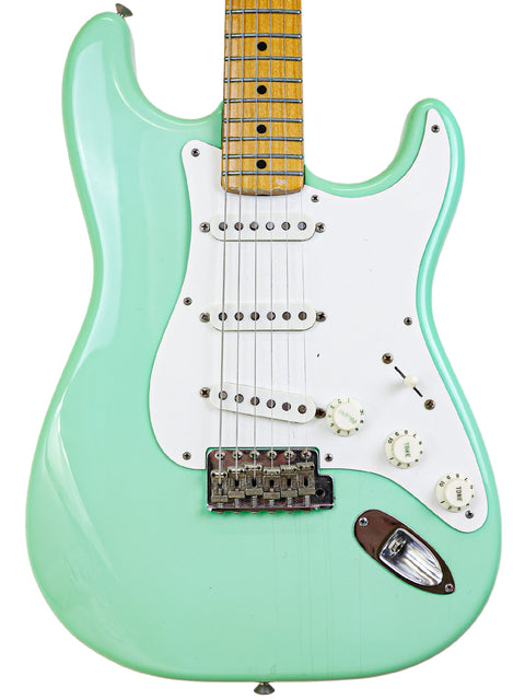 Vintage green Fender AVRI ‘57 Stratocaster electric guitar from 1985, showcasing a white pickguard.