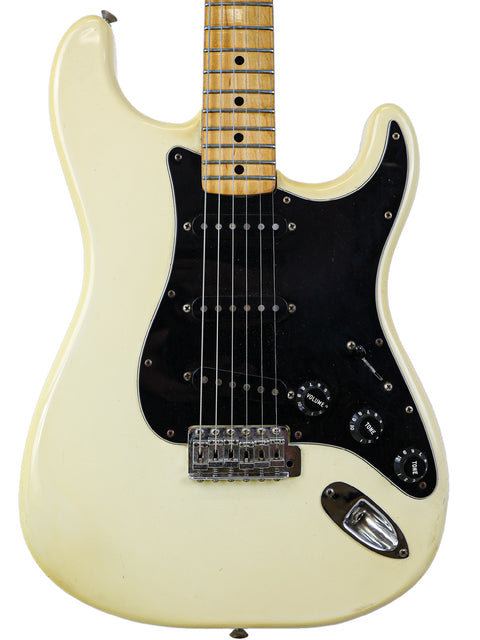 White 1977 Fender Stratocaster electric guitar with a black pickup, embodying vintage charm and musical excellence.