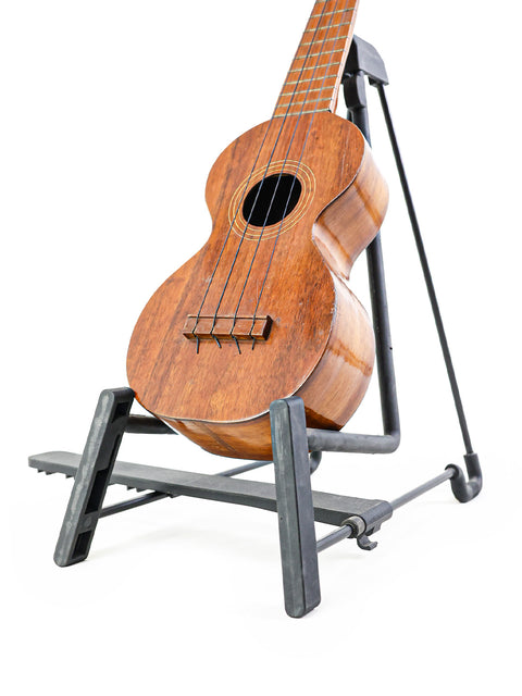 vintage Kumalae ukulele from the 1920s rests elegantly on a stand, showcasing its classic Hawaiian craftsmanship.
