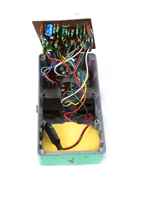 1979 Ibanez TS-808, a small device with wires and a yellow paper, showcasing vintage electronics.