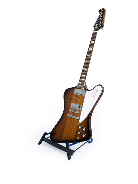 1991 Gibson Firebird V Reissue guitar displayed on a stand, featuring a striking white background for emphasis.
