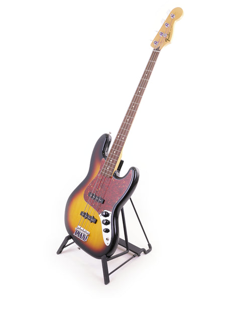 2013 Fender Jazz Bass guitar displayed on a stand, featuring a striking white background that highlights its elegant form.
