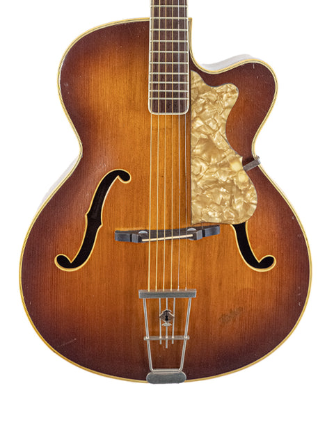 A 1950s Hofner 455 Archtop guitar with a warm brown body and neck, representing vintage German design and artistry.