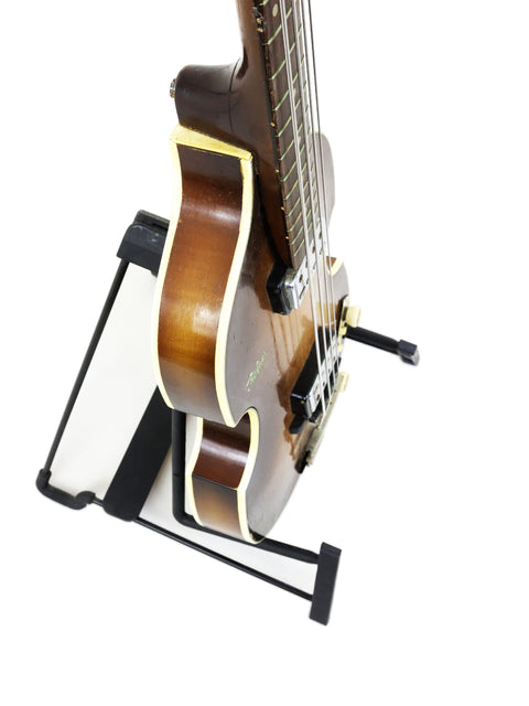 A 1962 Hofner 500/1 'Beatle Bass' guitar elegantly positioned on a stand, emphasizing its iconic design and heritage.