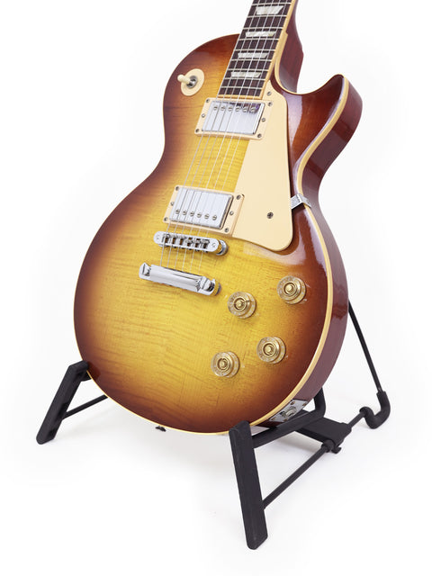 A 2009 Gibson Les Paul Standard guitar displayed on a stand, highlighting its iconic shape and craftsmanship.
