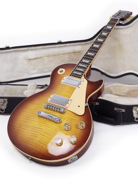 A 2009 Gibson Les Paul Traditional guitar and its case displayed on a bright white background.