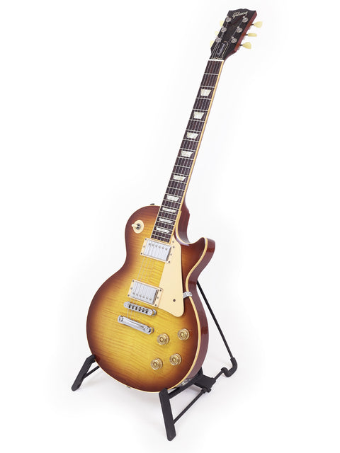 A 2009 Gibson Les Paul Traditional guitar resting on a stand, showcasing its classic design.