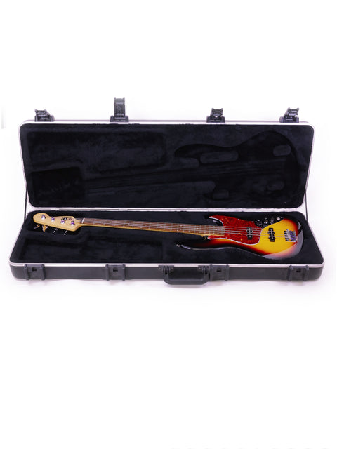 A 2013 Fender Jazz Bass guitar nestled in a case, displayed on a pristine white background, highlighting its elegant features.
