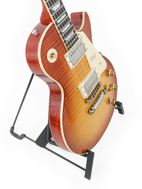 A 2018 Gibson Custom Shop '59 Les Paul Standard R/I guitar elegantly positioned on a stand with a white background.