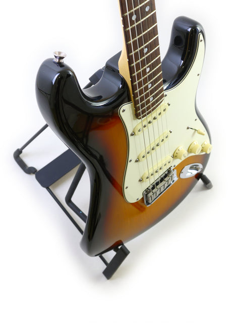 A Fender 60th Anniversary American Stratocaster guitar resting on a stand, set against a plain white background.