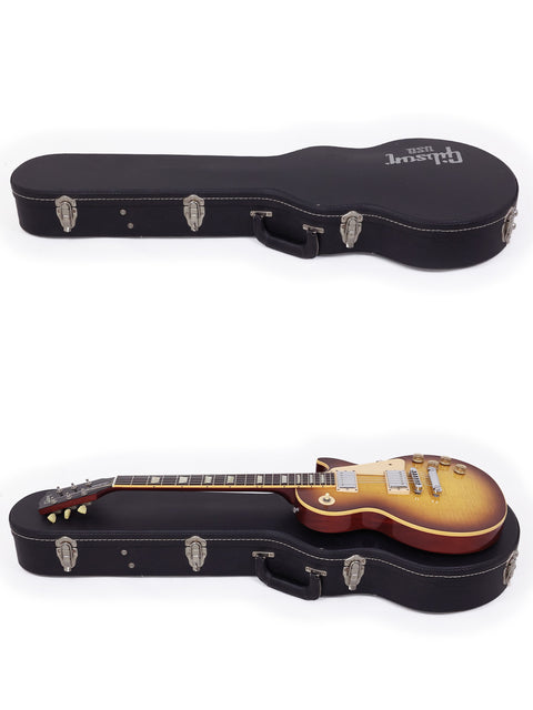 A Gibson Les Paul Traditional 2009 and another guitar are securely placed in a case, topped with an additional case.