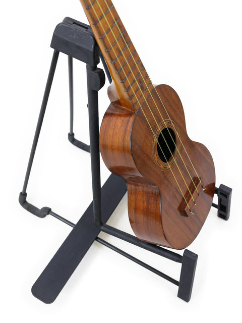A Kaai Style 2 Koa Ukulele, Hawaii, c. 1918, gracefully placed on a stand, representing vintage musical artistry.