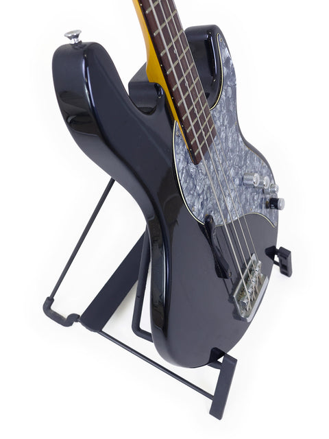 A Line 6 Variax Bass from 2004 displayed on a stand, featuring a minimalist white background that highlights its elegant form.