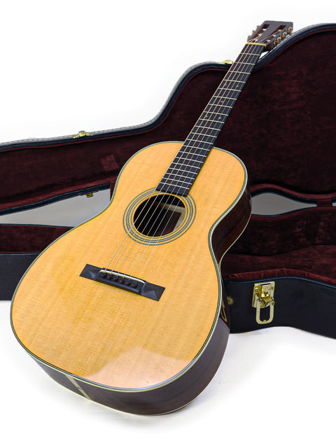 A Martin 00-28VS guitar nestled in its case on a white background, illustrating its beauty and quality.