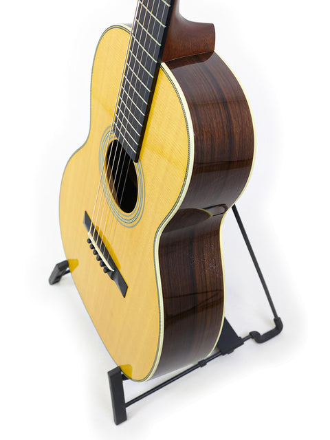 A Martin 00-28VS guitar on a stand against a clean white background, showcasing its elegant design.