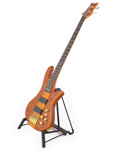 A Schecter Stiletto Studio 4 bass guitar elegantly displayed on a stand, with a minimalist white background highlighting its features.