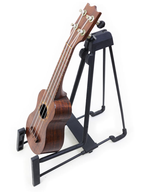A beautiful TABU Style 2 "Midget" Koa Ukulele from 1917, elegantly perched on a black stand for a stylish presentation.