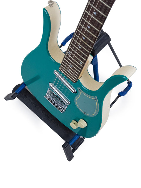 A blue electric guitar, the Jerry Jones Neptune Shorty 12-string, resting on a stand, showcasing its unique design.
