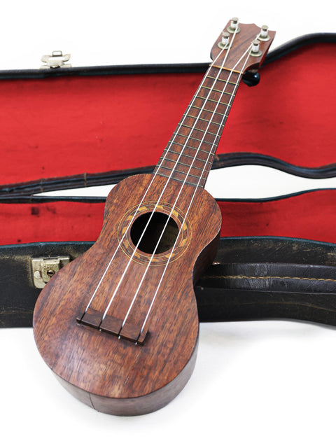 A classic 1917 TABU Koa Ukulele in its case, displayed on a bright white background.
