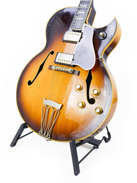 A classic 1966 Gibson Byrdland guitar displayed on a stand, representing vintage elegance and musical heritage.