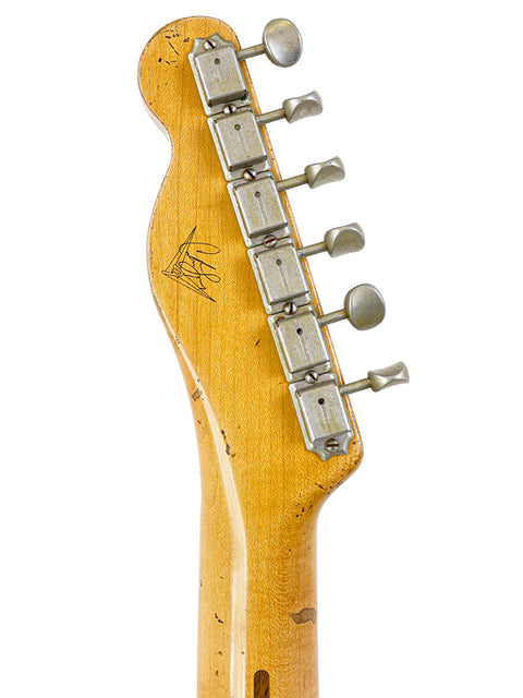 A detailed view of a guitar neck with a white backdrop, featuring the Fender Master Built Carlos Lopez 70th Anniversary Broadcaster.