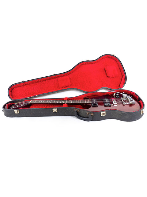 A red guitar case features a 1972 Gibson SG Pro, emphasizing the guitar's vintage appeal and bold red color.