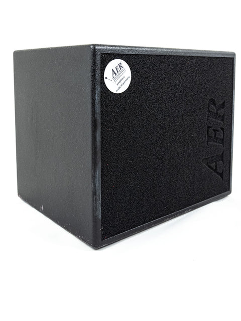 A sleek black box displaying "A - R," symbolizing the AER Domino 3 Stereo Acoustic Guitar Amplifier made in Germany, 2015.