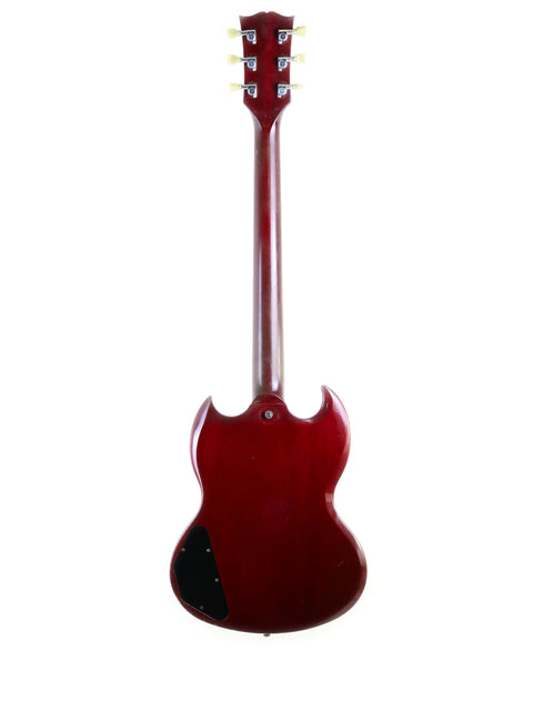 A striking red guitar, the Gibson SG '61 Reissue from 1988, adorned with a contrasting black pickguard for a classic look.