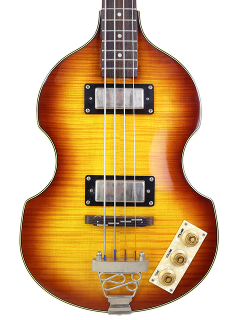 A vertical close-up of a sunburst electric bass guitar isolated on a white background.