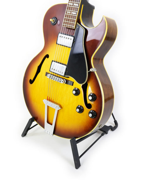A vintage Gibson ES-175D guitar from the 1970s displayed elegantly on a stand, showcasing its classic design.
