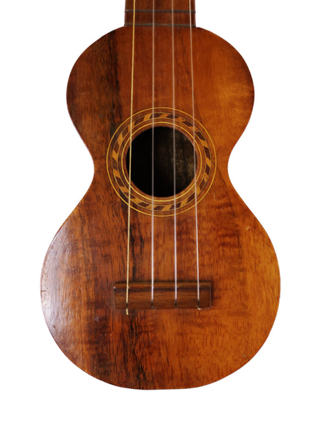 A vintage Kumalae Style 2 ukulele, crafted in Hawaii around 1913, with a beautifully aged wooden body and neck.