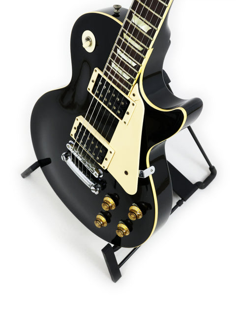A vintage black Tokai Les Paul Reborn LS50 electric guitar from 1979, resting on a stand.