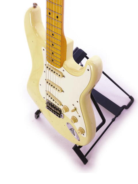 A white Fender Ltd Custom 50s Journeyman Stratocaster electric guitar displayed on a stand, showcasing its elegant design.