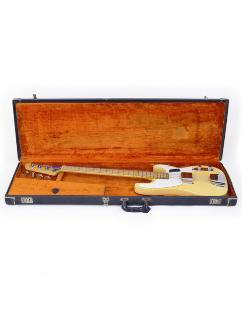 A white electric guitar, the 1968 Fender Telecaster Bass, resting in a wooden case, reflecting its vintage charm.