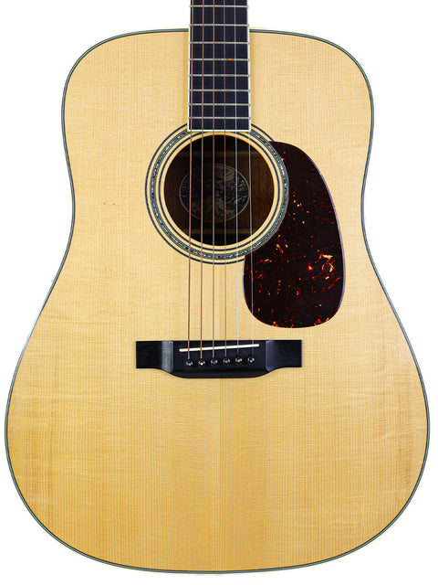 Acoustic guitar with natural finish and dark pickguard isolated on white background.