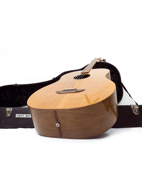 An Ernie Ball Earthwood Bass from the 1980s displayed in its case on a bright white backdrop.
