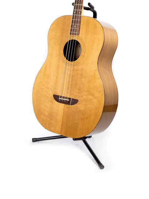 An Ernie Ball Earthwood Bass guitar from the 1980s showcased on a stand with a simple white background.